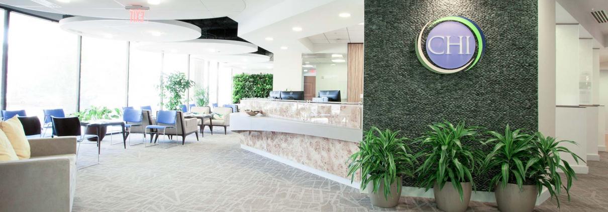Reception area with high-end natural finishes. Custom marble desk, seating areas and circular ceiling features