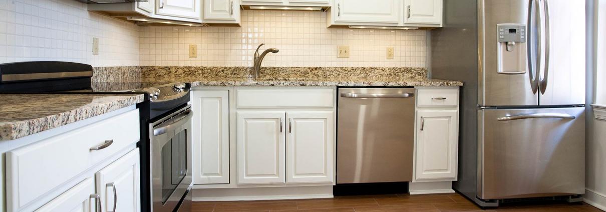 Senior living construction. Renovated kitchen with white cabinet and brown marble countertops