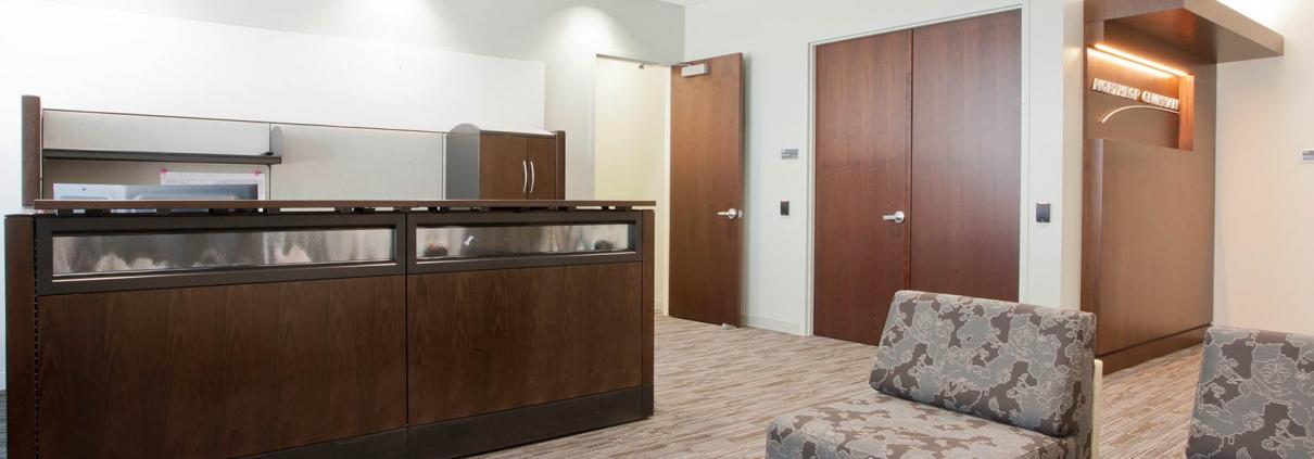 Reception area with dark wood reception desk seating area. Office construction by KasCon